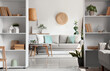 © Pixel-Shot - Interior of living room with comfortable sofa, tables and shelving units