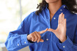 © Pixel-Shot - Young businesswoman using sign language in office, closeup