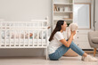 © Pixel-Shot - Screaming mother with her baby in crib suffering from postnatal depression at home