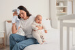© Pixel-Shot - Young mother with her baby and clothes suffering from postnatal depression in bedroom