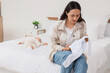© Pixel-Shot - Young mother with clothes and her baby suffering from postnatal depression in bedroom