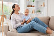 © Pixel-Shot - Young mother with her baby suffering from postnatal depression on sofa at home