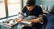 © photoplotnikov - Young caucasian male tattoo artist inking design on client's arm in studio