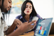 © Studio Marmellata - Diverse colleagues collaborate on a project. The man shows content on his smartphone while the woman observes and discusses, with a laptop open nearby.