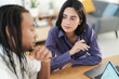 © Studio Marmellata - A diverse team of professionals collaborates in a modern office. A focused woman holds a pen, listening intently to her male colleague during a productive business discussion.