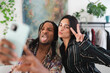 © Studio Marmellata - A diverse young man and woman take a fun selfie together. He makes a silly face with his tongue out, while she poses with a peace sign and a kissy face. They enjoy a playful moment.