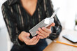 © Studio Marmellata - A person in a striped shirt holds a modern grey and white electronic device. They are inserting a white component into the gadget. A light indicator is visible on the device.
