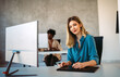 © NDABCREATIVITY - Young successful business woman using a computer while working in a startup company office