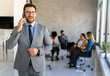 © NDABCREATIVITY - Successful executive standing proudly in office, representing business growth, partnership