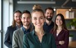 © Harper - Portrait of successful small group of business people smiling at camera at office. Empowered mature businesswoman standing with young adult coworkers as a team at workplace. High quality