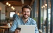 © Liam - Cheerful adult male freelancer using laptop and smartphone in cafeteria. High quality