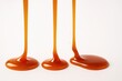 © Artcuboy - Caramel sauce streams flowing mid air into thin pool on white background for dessert topping food photography and confectionery themes