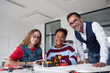 © Halfpoint - High school students working on robotics project with their teacher.