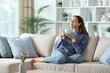 © PheelingsMedia - Relaxed woman in blue smelling coffee aroma at home