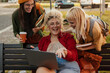 © La Famiglia - Diverse students laughing while watching content on laptop