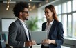 © shu - Happy busy professional smiling businessman and businesswoman having conversation at work. Executives team of two business people working talking using laptop technology standing in corporate office.