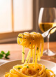 © Maria Polunina - Fresh fettuccine pasta twirled into a soft elegant nest, captured in warm natural light. Smooth texture, golden tones, minimal clean background, detailed close-up, modern Italian food styling.