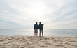 © Westend61 - Man standing with father in front of sea at beach