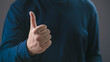 © Bordinthorn - close-up hand showing a thumbs up gesture against a dark background, symbolizing approval, positivity, success, agreement, encouragement, supportive communication in personal or professional contexts.