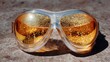 © CYBERPINK - Pair of safety goggles resting on a textured surface. the goggles have a clear frame and a transparent lens.