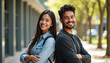 © miss irine - Young hispanic couple smiles posing back to back on college campus. Happy man, woman students stand together with crossed arms. Confident friends look at camera with joyful expression showing