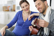 © auremar - beautiful pregnant woman and handsome husband playing acoustic guitar