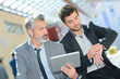 © auremar - businessmen holding tablet and looking at watch