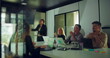 © Marco - African American businesswoman answering questions during team presentation while colleagues engage and observe in modern office conference room