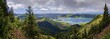 © Michael Rucker/imageBROKER - Wide panorama of the crater lake Lagoa Azul surrounded by lush green hills and clouds in the sky, crater circular hiking trail, Caldeira das Sete Cidades, Lagoa Azul, Sao Miguel, Portugal
