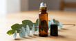 © Olga - Essential oil roller bottle beside eucalyptus sprig on wooden table