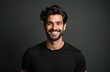 © miss irine - Young man with beard and styled hair smiles in a black t-shirt. His friendly expression and dark background make him ideal for professional or lifestyle content. He looks confident and approachable.