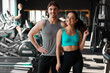 © Home-stock - Happy European man and woman trainers posing in modern gym and smiling at camera, standing together, radiating positive and healthy lifestyle