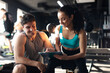 © Home-stock - Man trainer and woman engaged in discussion in gym, reviewing plan of training, likely focusing on workout or nutrition plan