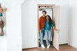 © Prostock-studio - A young couple stands at the doorway of their new home, smiling and excited. The bright room has neutral colors and a cozy feel. They are ready to start this new chapter together.