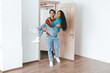 © Prostock-studio - A man lifts a woman joyfully in an empty room with wooden floors and bright light from a door. They are excited about moving into their new home together.