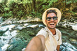 © Davide Angelini - Happy man taking selfie on jungle river background - Smiling hiker having fun on adventure trip - Technology life style concept