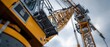 © Fernando - Low angle view of a yellow mobile crane against cloudy sky Concept of construction, industry, heavy equipment, and engineering