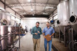 © Jelena - Brewery workers discussing production while inspecting facility