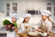 © BillionPhotos.com - Little girl in hat cooking with mother in kitchen room
