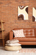 © Pixel-Shot - Cozy sofa and pouf with pillows in interior of living room
