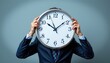 © K-MookPan - Businessman Holding Clock in Front of Face, Symbolizing Time Management and Work-Life Balance in Modern Office