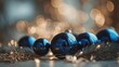 © ali - Close up of shimmering blue christmas ornaments on a pine branch with soft golden bokeh lights in the background