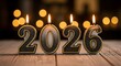 © Jahangir - Lit 2026 candles with gold trim on a rustic wooden surface with bokeh lights new year fire