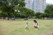 © leungchopan - Baby walking on grass with mother at park