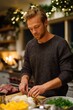 © Iryna - Young caucasian male preparing meal in festive kitchen with holiday decorations