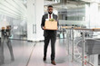 © Prostock-studio - Unhappy young black man in suit employee got fired from job, walking by modern office, holding box with his belongings, looking angry and upset, copy space, full length shot. Unemployment concept