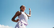 © peopleimages.com - Happy woman, fitness and winning with blue sky for race, sprint challenge or marathon in city. Low angle, female person or runner with smile for victory, achievement or accomplishment on mockup space