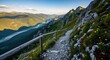 © Jurdi - Narrow Mountain Trail with Wooden Railing Overlooking Valley at Sunset.