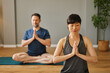 © Stockphotodirectors - Yoga instructor meditating with student at home or studio