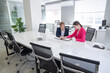 © Михаил Решетников - Man and woman talking while sitting at desk in office.